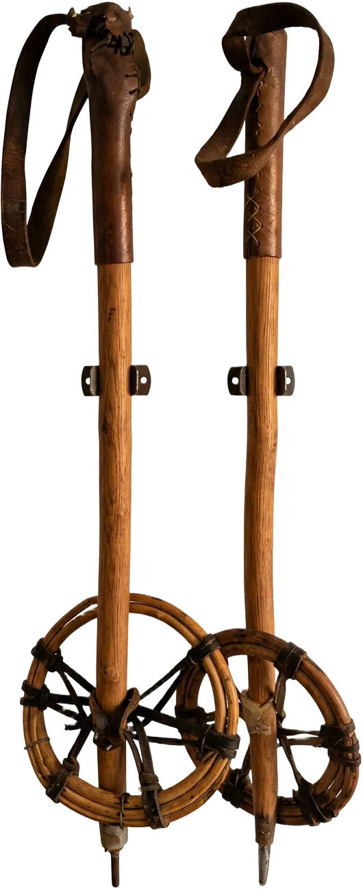 Bâtons de ski anciens en bois et cuir fixés en diagonale au mur